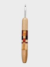 Wooden-handled crochet hook on a light gray background
