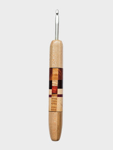 Wooden-handled crochet hook on a light gray background