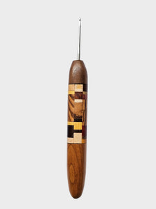 Wooden crochet hook with a patterned handle on a light gray background