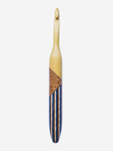Crochet hook with wooden handle and black and blue striped shaft on white background