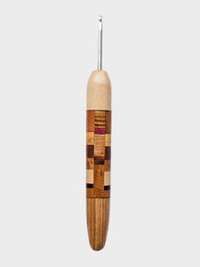 Wooden crochet hook with a checkered pattern on a gray background