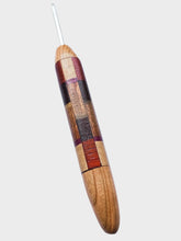 Wooden crochet hook with a patchwork design on a white background