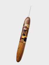 Wooden crochet hook with multicolored inlay on a light gray background