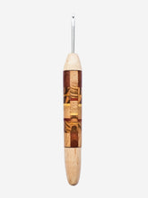 Wooden crochet hook with metal end on a light gray background