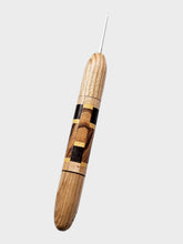 Wooden crochet hook with a metallic needle on a white background