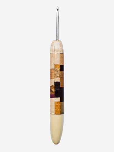 Wooden crochet hook with a patterned handle on a light gray background