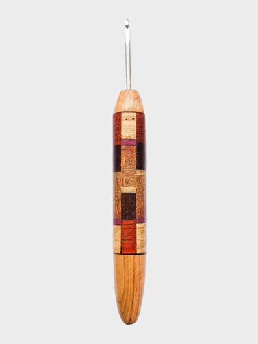 Wooden crochet hook with a patterned handle on a white background