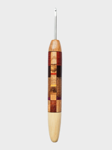 Wooden crochet hook with a checkered pattern on a light gray background