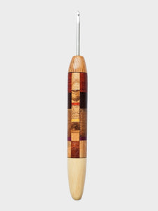 Wooden crochet hook with a checkered pattern on a light gray background