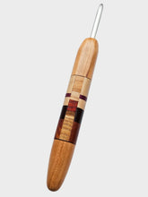 Wooden crochet hook with a metal tip on a light gray background