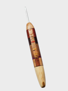 Wooden crochet hook with a metal tip on a gray background
