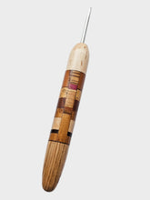 Wooden crochet hook with a metal tip on a gray background