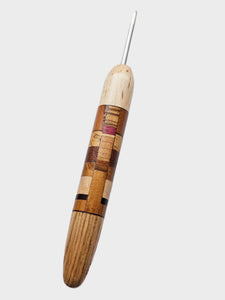 Wooden crochet hook with a metal tip on a gray background