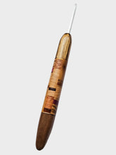 Wooden crochet hook with a white shaft on a light gray background