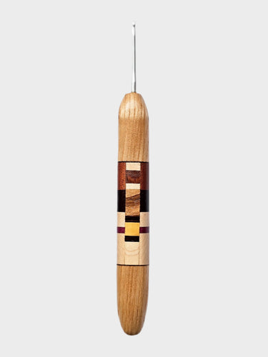Wooden crochet hook with a patterned handle on a white background