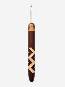 Wooden crochet hook with decorative pattern on a white background