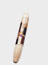 Wooden crochet hook with multicolored pattern on a white background