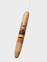Wooden crochet hook with a metal tip on a light gray background
