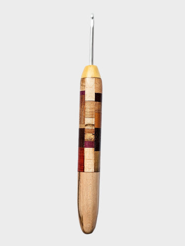 Wooden crochet hook with multicolored handle on a white background