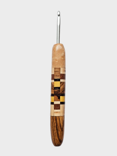 Wooden crochet hook with a checkered pattern on a gray background